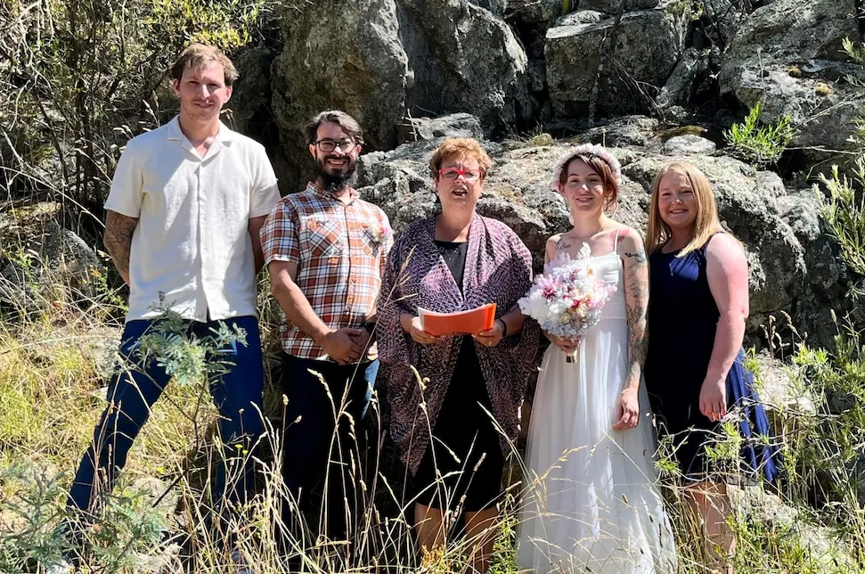 Josie with a wedding couple and their guests outdoors