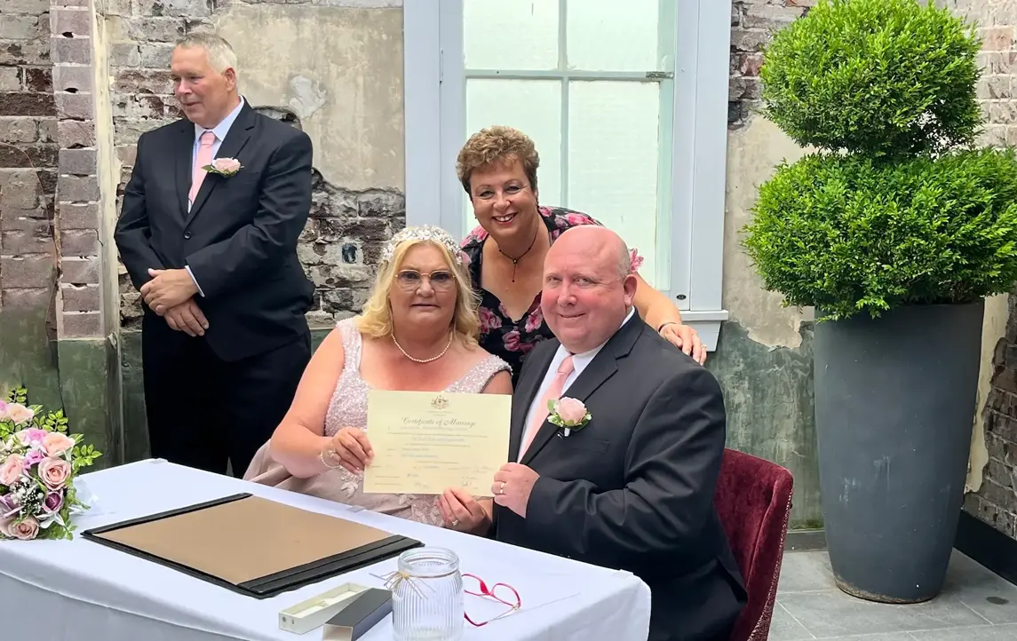 A couple signing their marriage paperwork with Josie