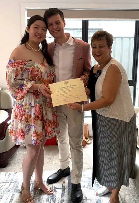 Josie with a couple holding their marriage certificate