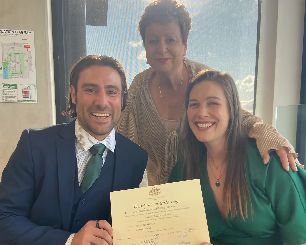 Josie with a couple and their marriage certificate